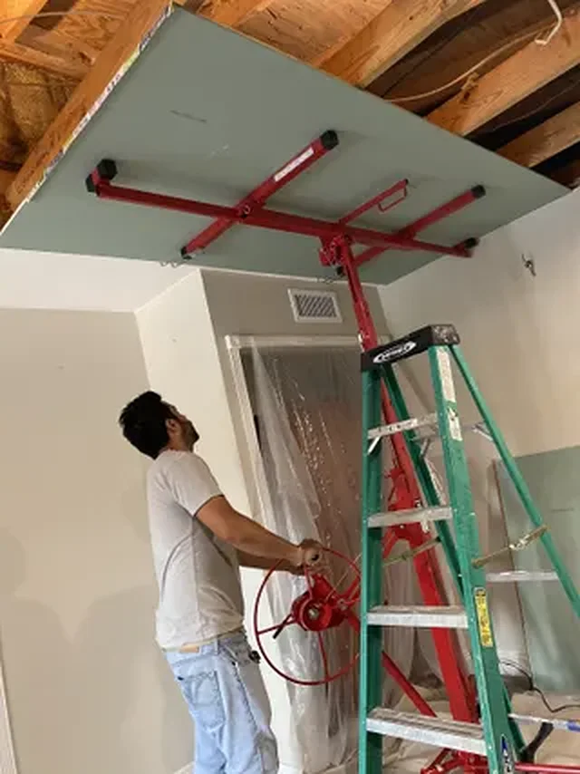 VNX technician installing a drywall ceiling with a panel lift