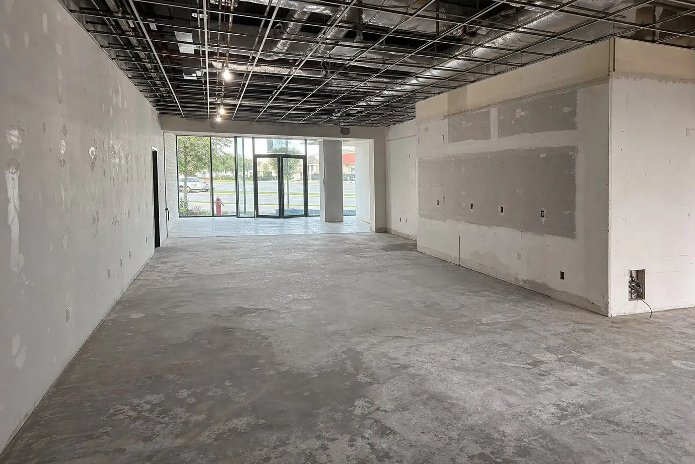 Empty commercial space with open ceiling before the build-out
