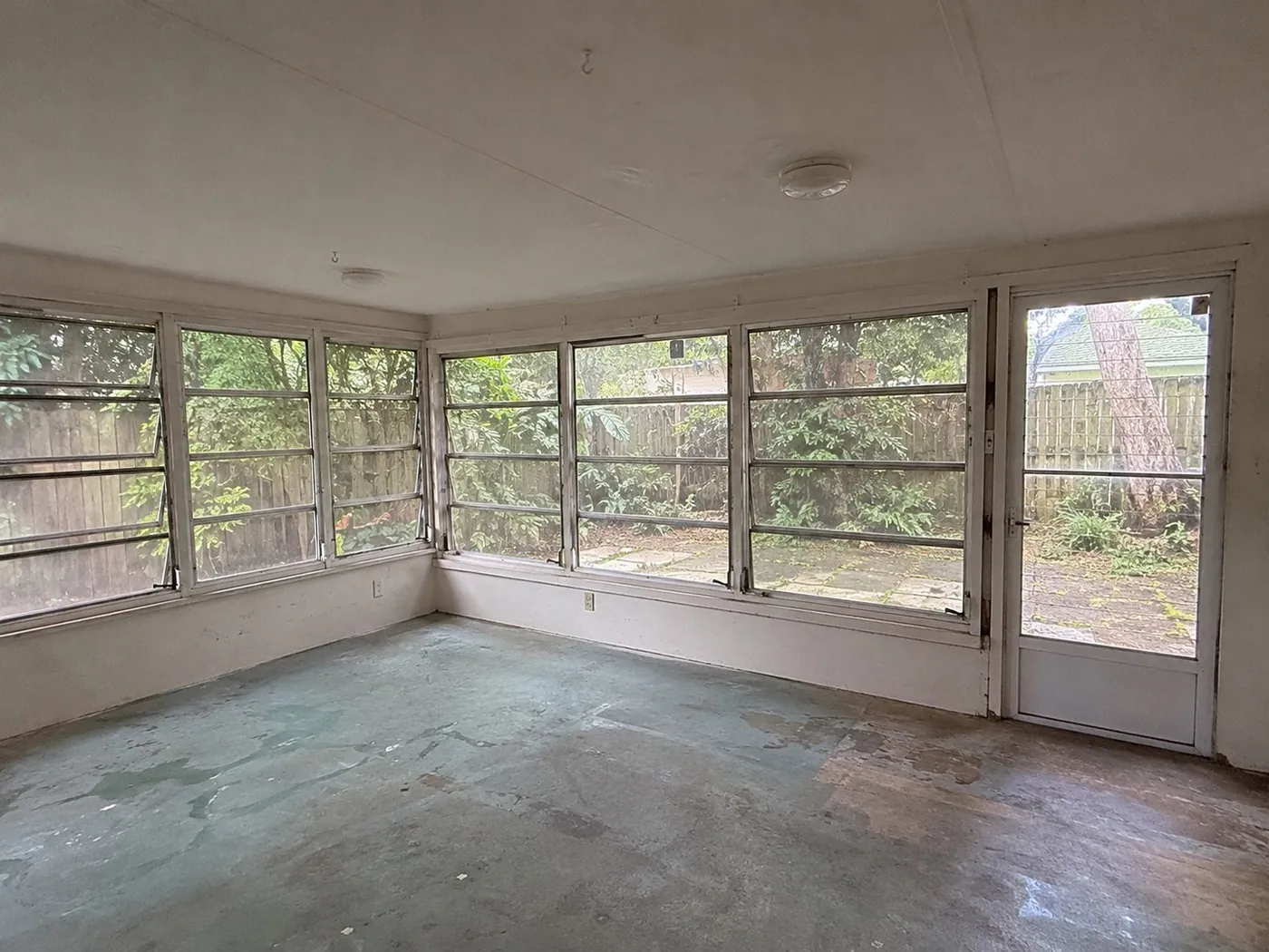 Sunroom with bare concrete floor before the remodel